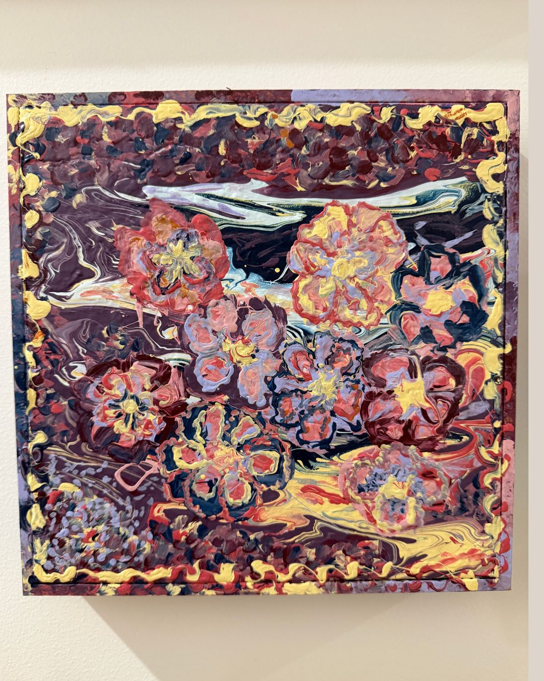 Abstract painting with vibrant colors on a beige wall