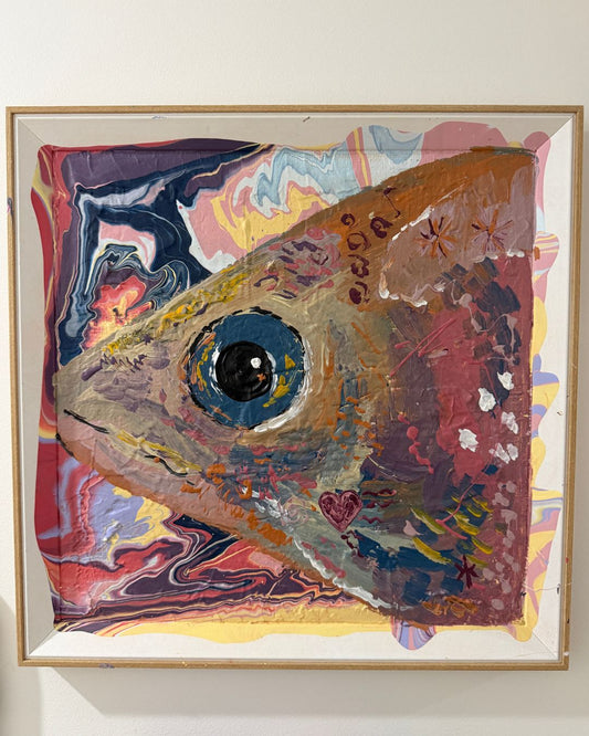 Framed abstract artwork with a colorful fish-like shape on a white wall