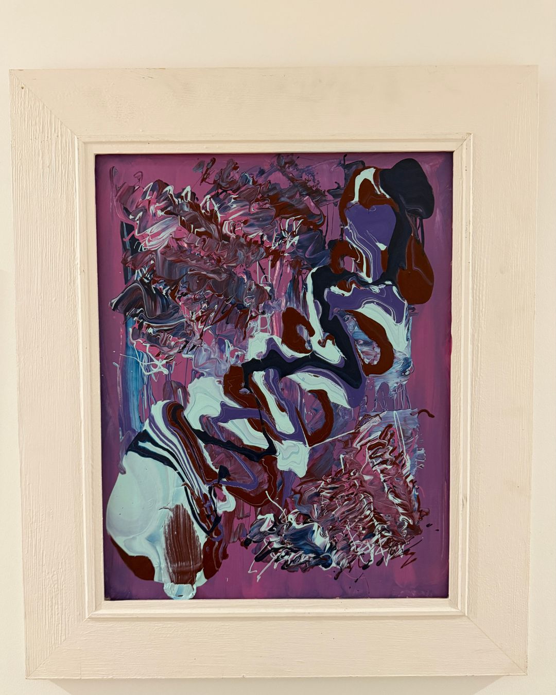 Abstract painting with purple and brown tones in a light wood frame.