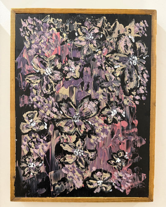 Abstract floral artwork with a wooden frame on a beige wall